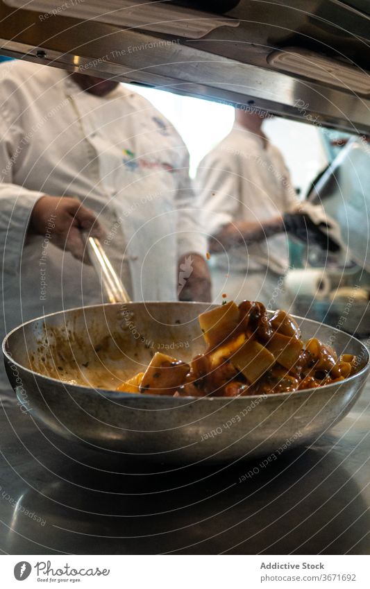 Anonymous chef mixing dish on frying pan ingredient cook restaurant kitchen food culinary cuisine yummy dinner gourmet modern delectable job meal professional