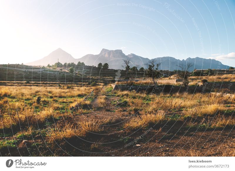 Former farmland on the countryside of Costa Blanca during sunset with lit mountains, La Nucia, Spain travel nature landscape desert rock wasteland hill spain