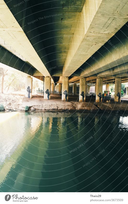 Green river water under the bridge cement construction, reflection on water lines engineering structure industry perspective bridge construction silhouette