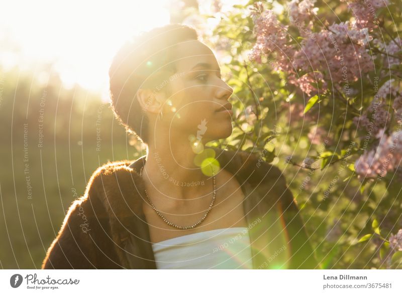 Woman in front of lilac tree #4 Young woman girl Teenage Girls teenager out Nature Lilac Tree shrub Lilac bush Sun sunny Sunlight Mixed Afro-German Curl Coat