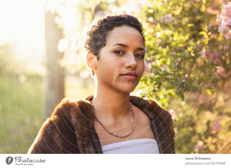 Woman in front of lilac tree #3 Young woman girl Teenage Girls teenager out Nature Lilac Tree shrub Lilac bush Sun sunny Sunlight Mixed Afro-German Curl Coat