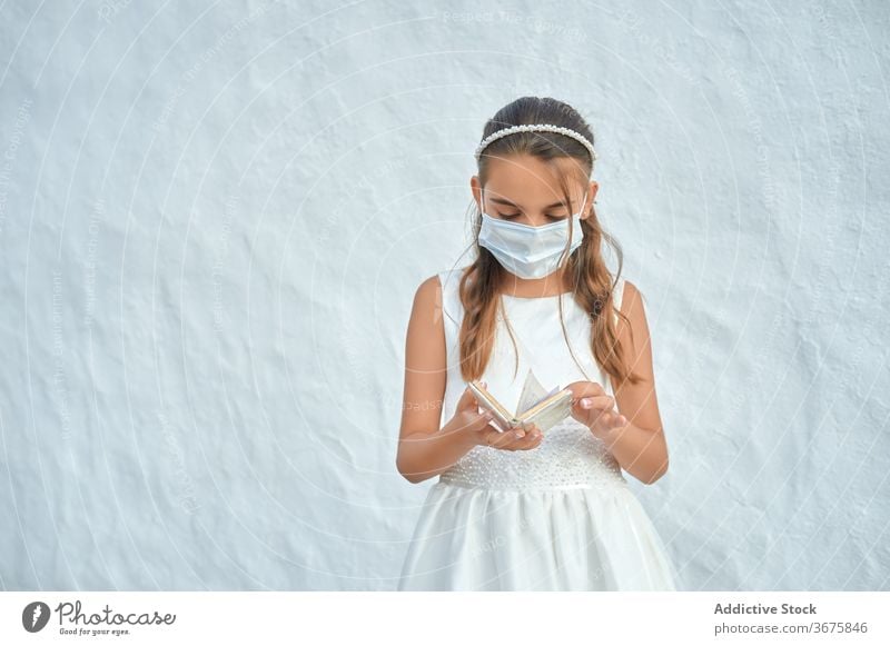 Girl in a protective mask on her first communion girl coronavirus preteen christian prevention corona virus innocent religious religion female dress catholic