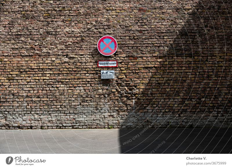 Absolute no stopping I No stopping sign on brick wall in front of fire area no stopping sign Fire brigade area Towing sign tow old brick wall Wall (building)