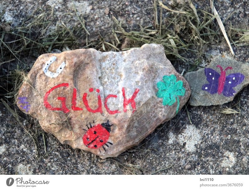 two lucky stones painted with horseshoe ladybug cloverleaf butterfly Stone Sharp-edged Flat Happy Ladybird Cloverleaf Horseshoe Butterfly colored