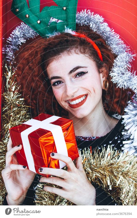 Beautiful redhead young woman with christmas stuff holidays gift people real pretty youth happy happiness merry christmas decor decoration hairband horns