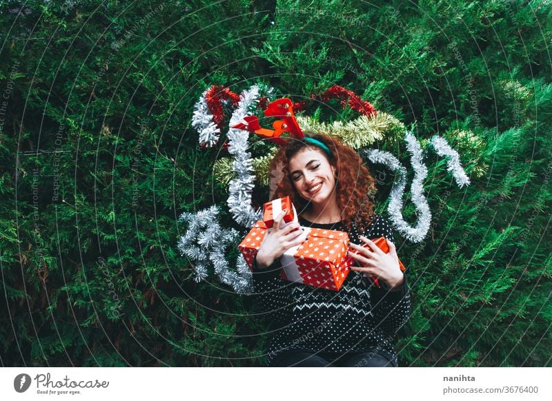 Young happy redhead woman near a christmas tree on holidays gift people real pretty young youth happiness merry christmas decor decoration hairband horns