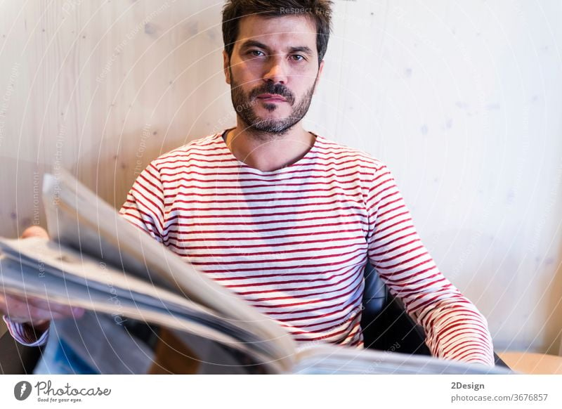 Adult man reading newspaper sitting in sofa 1 male people indoor lifestyle caucasian business beard portrait photogenic home person attractive smile senior