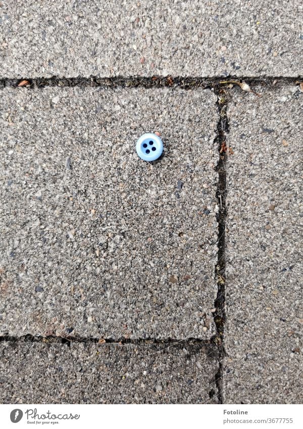 Jim Knopf - or a small blue button lies on the cobblestones of a sidewalk knob Detail Colour photo Clothing Fashion Blue Deserted Close-up Day