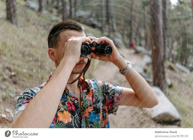 Traveler exploring nature with binoculars in forest man hike mountain explore travel activity trekking young discovery adventure spain navacerrada madrid male