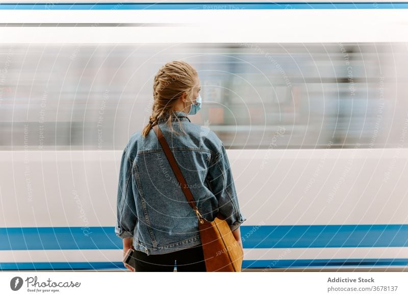 Young woman in mask waiting for subway train metro coronavirus passenger platform covid pandemic infection protect female casual young underground station