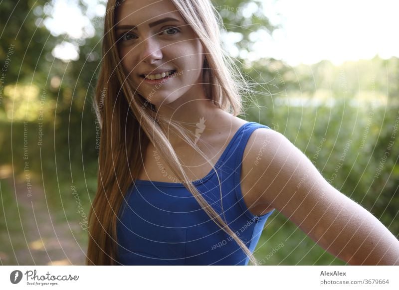 Lateral portrait of a young woman in a blue summer dress in the nature Purity luck Beautiful weather Trip Expectation Sunlight Close-up Day