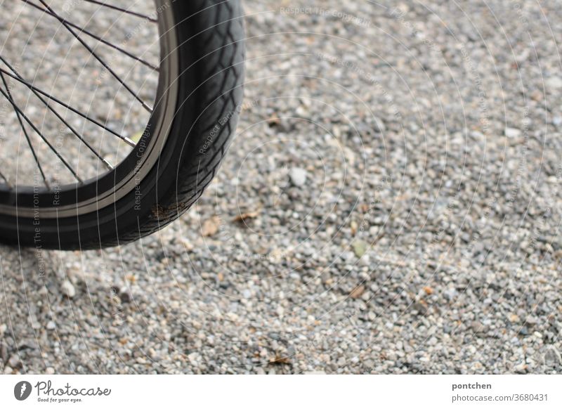 Part of a bicycle tyre on gravel. Mobility Bicycle Bicycle tyre turnaround Gravel Environmental protection Spokes Sports Monochrome out Cycling