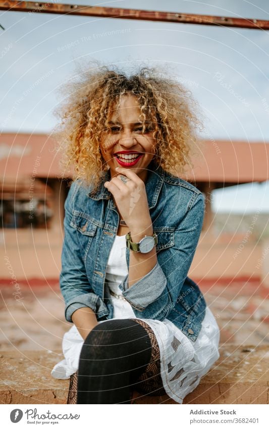 Stylish ethnic woman on old bridge style grunge trendy fashion shabby railing sit confident female african american black charming smile content calm joy