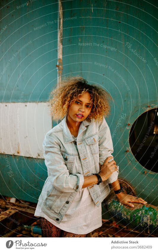 Ethnic woman in abandoned building millennial style trendy generation grunge independent female ethnic black african american city urban stand denim weathered