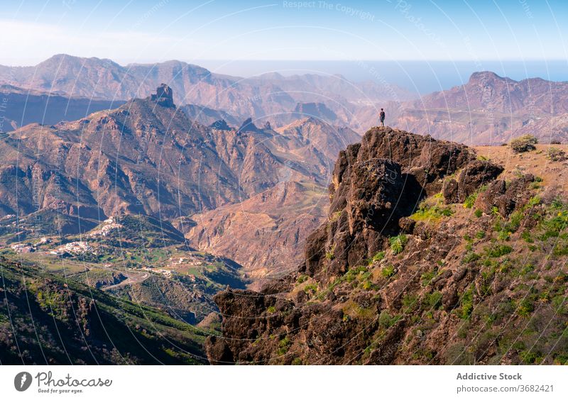 Traveler on high peak in mountains highland rock traveler hill admire enjoy rough stone rocky gran canaria spain tourist breathtaking amazing nature adventure