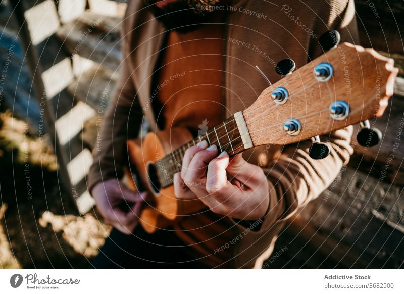 Anonymous male traveler resting near fence man mountain lean sunny daytime puerto de la morcuera spain countryside wooden ukulele barrier relax nature journey