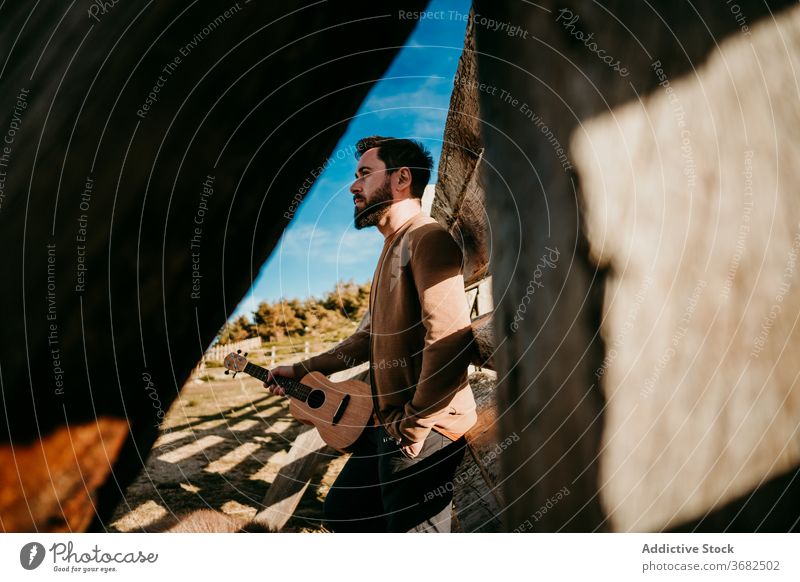 Male traveler with dog resting near fence man mountain lean sunny daytime puerto de la morcuera spain male countryside wooden ukulele barrier relax nature