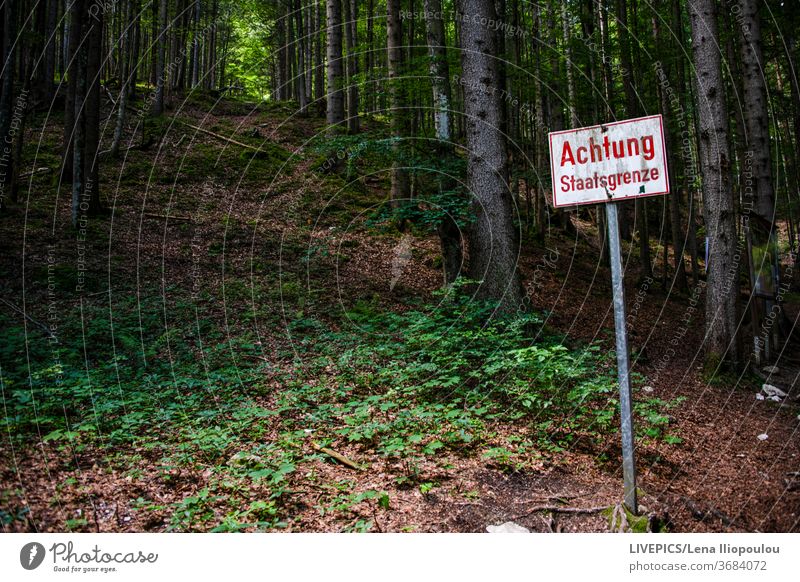 Sreet sign "attention state border" background beware copy space day daylight forest frontiers green information landscape nature path pathway street sign