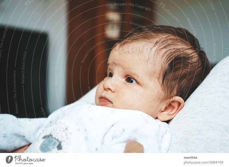 Lovely newborn baby girl with a warm pajama at home cute adorable funny boy kid daughter son face expressive expression growth upbringing nurture skin issues