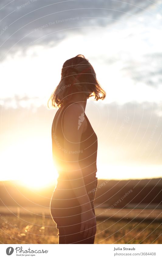 sunrise woman on meadow Field Sunlight Sunset Short-haired Clouds Arable land Warmth Sunbeam Horizon Summer evening diffuse light Orange T-shirt Sleeveless