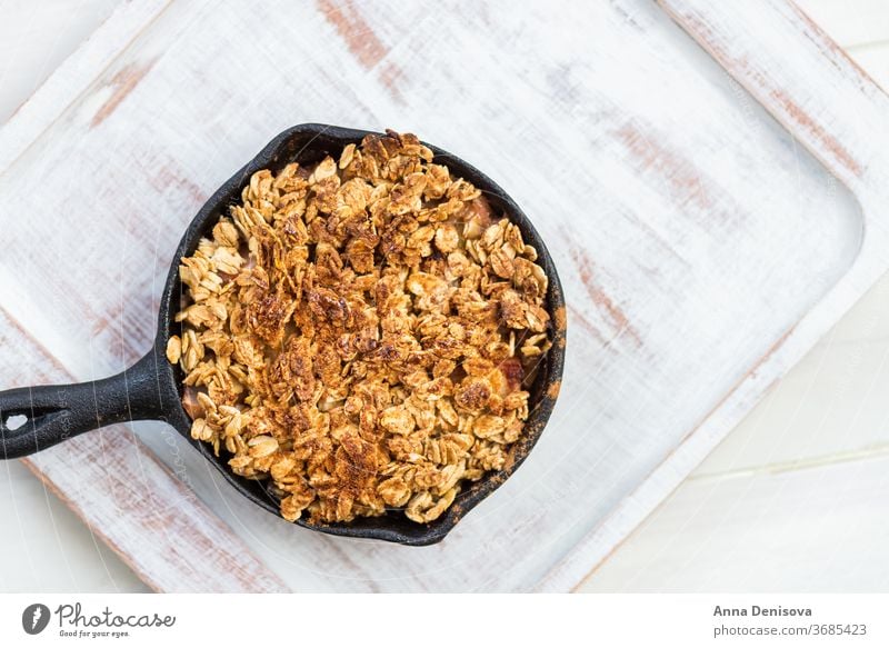 Homemade cooked rhubarb and apple crumble with oatmeal berry healthy fruit cake cobbler food strawberry wooden pan sweet dessert rustic homemade pie cast iron