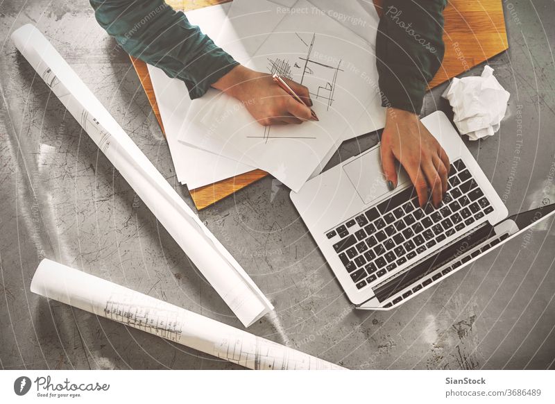 Top view of architect woman sketching in her office laptop business workplace computer hands breakfast keyboard desk table working technology notebook coffee up