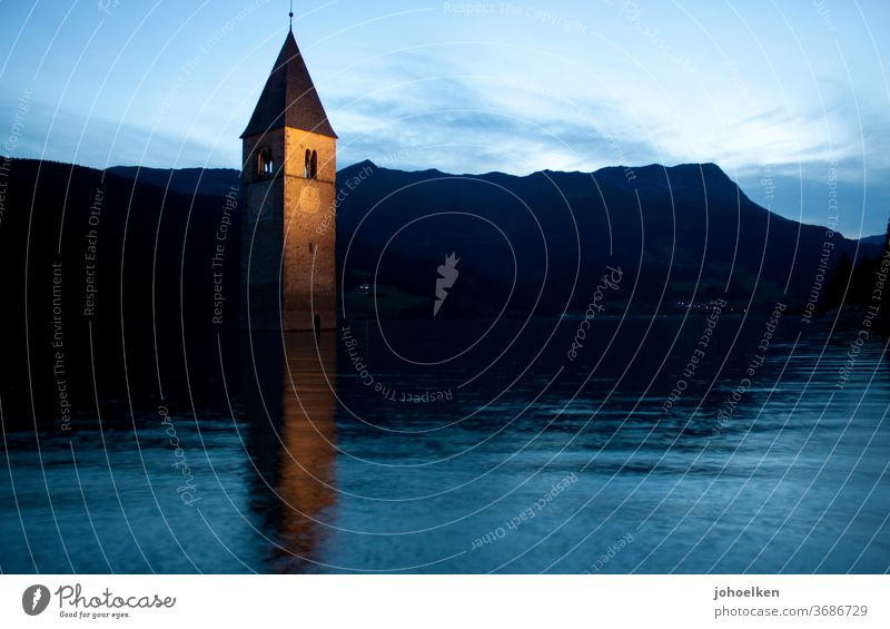 Church in the Reschensee Lake Reschen Church spire drowned underwater Deluge Tower clock Flood evening mood mirror Water Dusk downfall Go under Mountain Alps