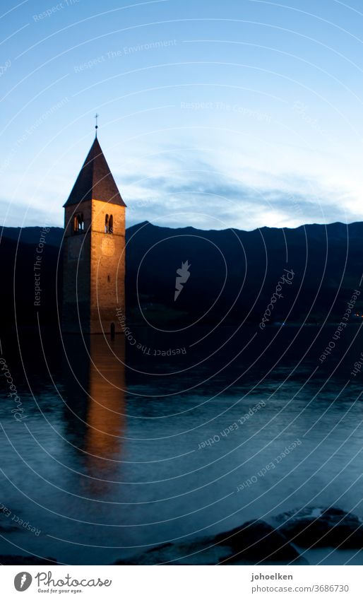 Church in the Reschensee Lake Reschen Church spire drowned underwater Deluge Tower clock Flood evening mood mirror Water Dusk downfall Go under Mountain Alps