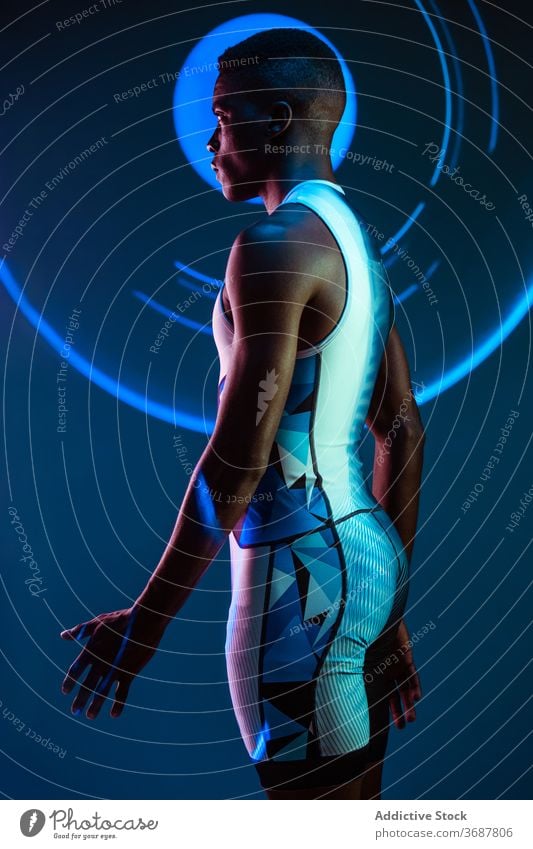 Strong ethnic sportsman looking away athlete confident serious concentrate brutal competitive determine neon challenge blue active physical young black