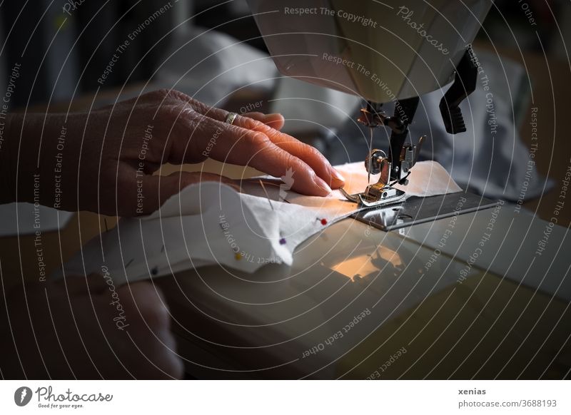 A woman's hands sewing a mouthguard at the sewing machine / corona thoughts Sewing Sewing machine Woman Mask Tailoring Cloth Profession Work and employment