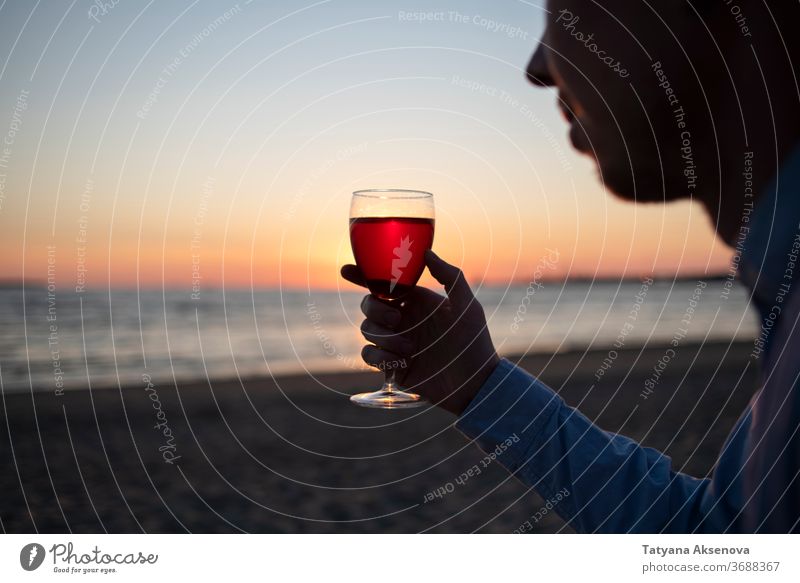 Man with glass of wine on beach at sunset drink alcohol romantic enjoying slow living relax sea beautiful celebration beverage silhouette romance holiday nature