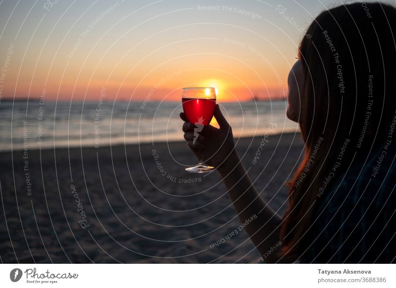 Woman with glass of wine on beach at sunset drink alcohol romantic enjoying slow living relax sea beautiful celebration beverage silhouette romance holiday