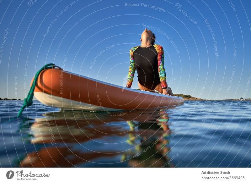 Flexible woman doing yoga on paddleboard sunset pose surfer balance sea female water healthy nature harmony relax tranquil serene sky calm ocean peaceful lady