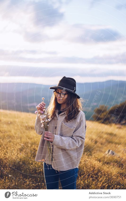 Carefree woman with flowers on hill tender bouquet wildflower mountain sunset blossom highland female sundown majestic landscape autumn dusk tranquil calm