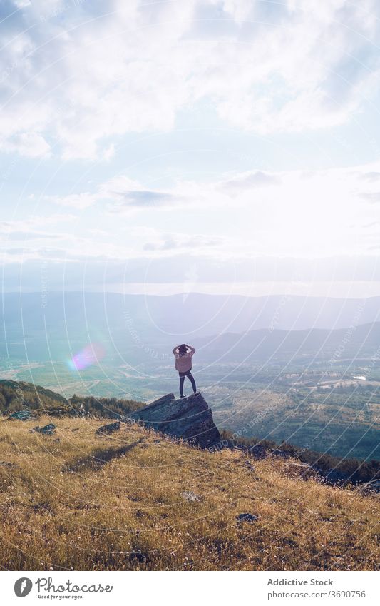 Unrecognizable tourist woman on rock in mountains landscape traveler valley admire highland vacation sunny hill together nature tourism amazing stone rough trip