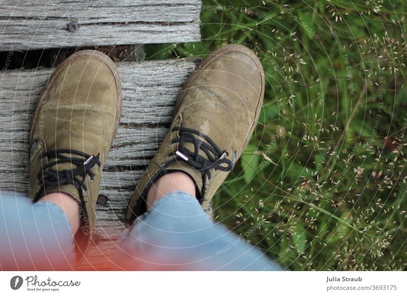 Shoes standing on wooden bridge photographed from a bird's eye view Footwear ecologic Sustainability Leather Cork Grass green Nature boards Screw Jeans