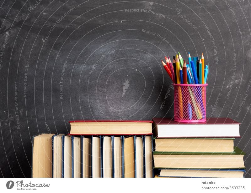 stack of various books, stationery on black chalk board background, back to school archive blackboard blank brown business chalkboard closed collection college