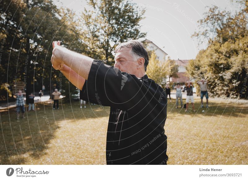 Qi Gong practice on the meadow Qi gong qi Meditation Outdoors Zen Movement Park Energy loosen up Healthy TCM Traditional Chinese Medicine Man attentiveness