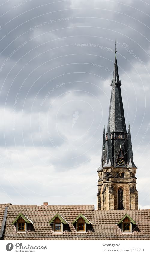 Opposites | in the overall height Overall height Building height Church spire Wernigerode house roof dormers Sky Clouds in the sky cloudy Exterior shot