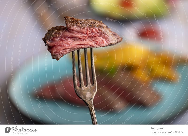 Disc steak on a fork Steak Beef beef steak medium Impaled slice Slice Sirloin Frying roasted Meat Juicy Cut Fork silver fork Red Eating Raw English background