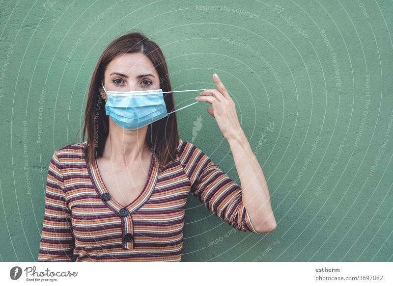 woman wearing medical mask holding a protective medical mask coronavirus young woman epidemic pandemic quarantine covid-19 symptom medicine health