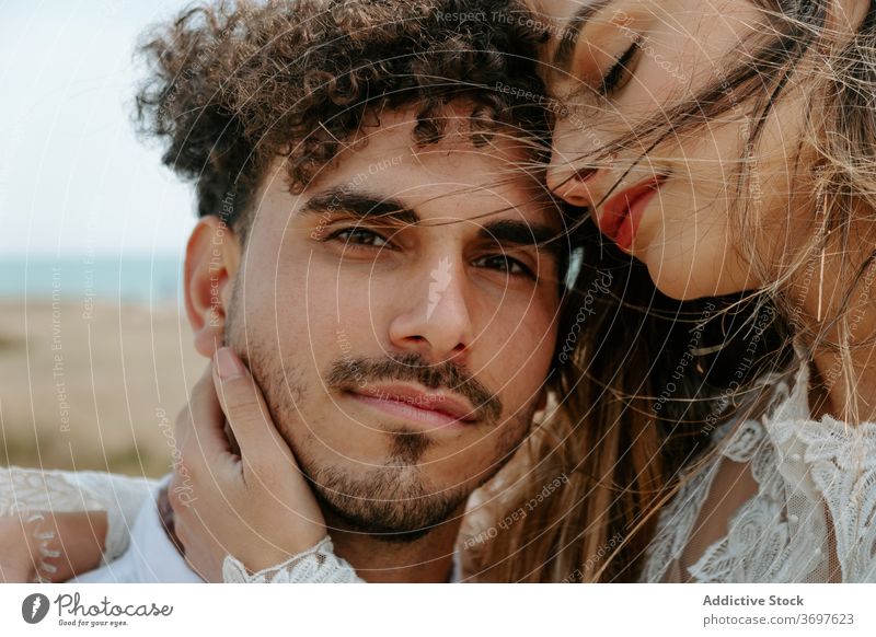 Happy newlywed couple hugging on beach romantic happy cuddle gentle enjoy together relationship love embrace marriage tender cheerful sensual smile content