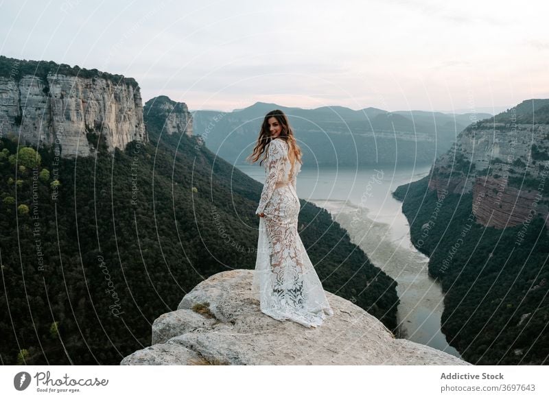 Elegant young bride standing on rocky cliff woman mountain dress romantic newlywed edge nature happy charming wedding spain morro de labella barcelona style