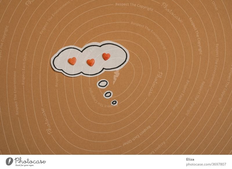 A thought bubble on beige background with 3 hearts in it. Infatuation, love and feelings. Valentine's Day. cuddle Love Head thoughts Romance bubble of thought