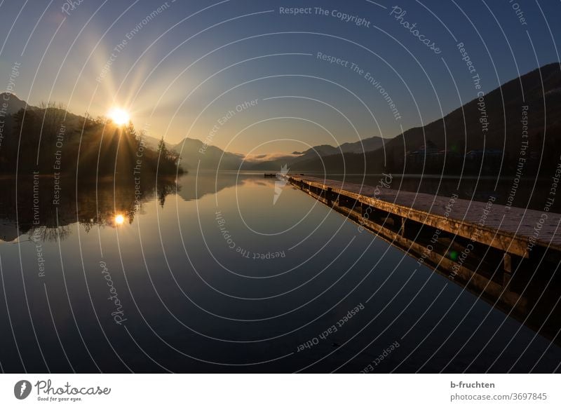 Dawn at the lake, big long wooden jetty Mountain lake Sunlight Nature Landscape Alps Colour photo Lake Deserted Water Sky Blue Reflection Relaxation