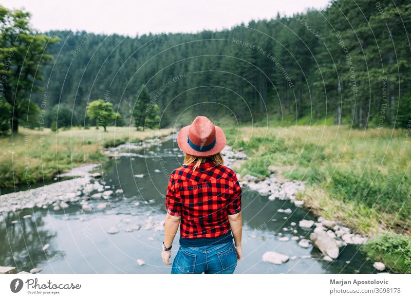 Young woman enjoying the great outdoors by the river in the mountains active adventure casual creek discovery environment expedition explore explorer female