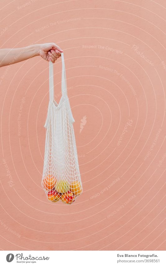 woman holding cotton bag with fruit. Eco friendly, zero waste concept unrecognizable city urban consumer green environment buy money pursed reduce net