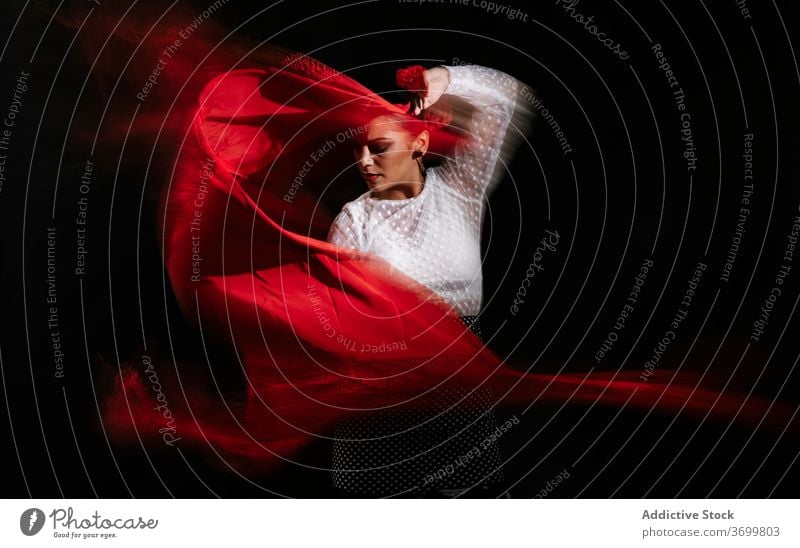 Passionate woman dancing Flamenco against black background flamenco dance perform passion hispanic tradition grace move elegant dancer young female red style