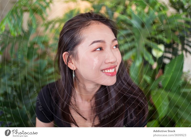 Ethnic woman in botanical garden relax smile happy plant laugh natural female ethnic joy asian calm rest charming enjoy tranquil peaceful glad outfit lady