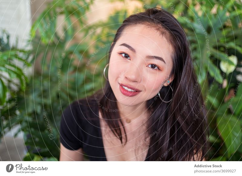 Ethnic woman in botanical garden relax smile happy plant laugh natural female ethnic joy asian calm rest charming enjoy tranquil peaceful glad outfit lady